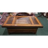 A COFFEE TABLE, with copper inserts and a lift top glazed central area, 8 small drawers to the base,