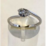 A 9CT WHITE GOLD DIAMOND RING, finished with two round brilliant cut diamonds in a 9ct gold twist