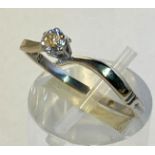 AN 18CT WHITE GOLD DIAMOND SOLITAIRE RING, hallmarked, set in a love twist band, the diamond is claw