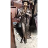 A DECORATIVE FIGURE OF A MAN PLAYING AN INSTRUMENT