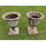 A GOOD QUALITY PAIR OF 19TH CENTURY CAST IRON GARDEN URNS, original, with beautiful fluted body