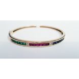 AN 18CT YELLOW GOLD BANGLE SET WITH EMERALDS, RUBIES, SAPPHIRES & DIAMONDS