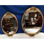 TWO GILT OVAL SHAPED WALL MIRRORS, both with floral decoration, smaller: 43cm x 65cm approx, larger: