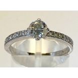 AN 18CT WHITE GOLD DIAMOND SOLITAIRE RING, finished with diamond shoulders in a hand made setting,