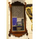 A SCROLL SHAPED MAHOGANY MIRROR, with gilt slip, 33” x 17” approx