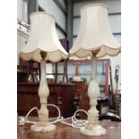 A PAIR OF PALE GREEN OYNX TABLE LAMPS, each with curved columns terminating with carved ring base,