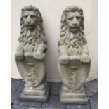 A PAIR OF STONE GARDEN ORNAMENTS IN THE FORM OF LIONS holding shields 85 high