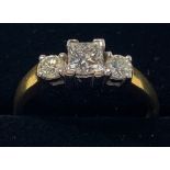 AN 18CT YELLOW GOLD THREE STONE DIAMOND RING, with a princess cut centre stone and two round cut