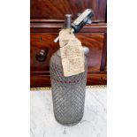 A VINTAGE "SPARKLET SYPHON" BOTTLE, with original label, the bottle covered in metal mesh,