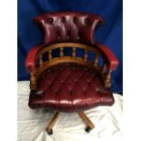 A GOOD QUALITY RED LEATHER ADJUSTABLE DESK CHAIR, with turned wooden arm supports and button backed