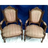 A PAIR OF VICTORIAN WALNUT ARMCHAIRS, each with curved shield backs having carved decoration to