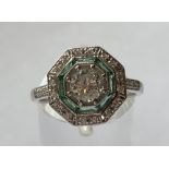 AN 18CT WHITE GOLD ART DECO DIAMOND & EMERALD TARGET RING, centre diamond .60 cts with an outer ring