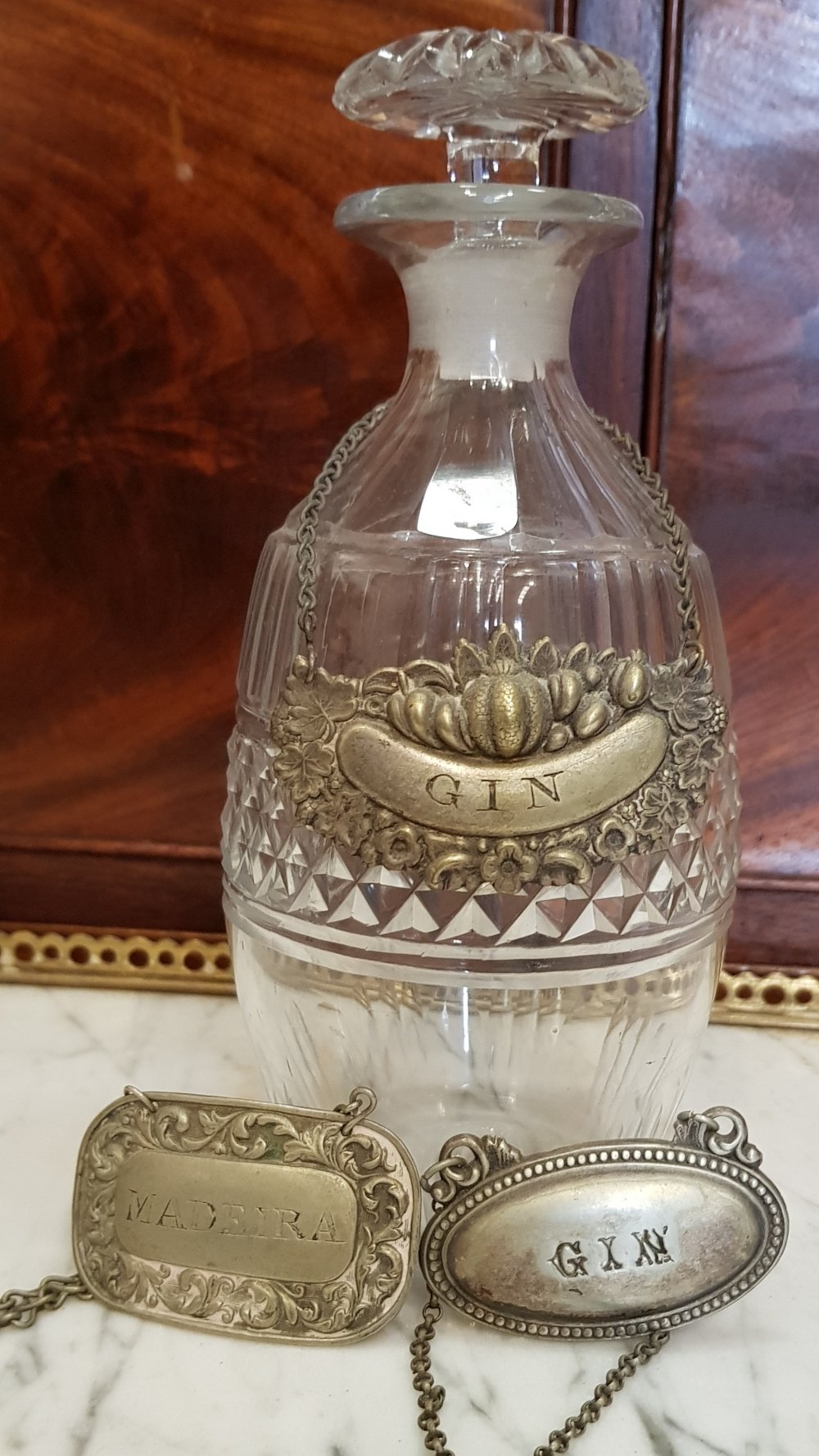 A 19TH CENTURY GLASS DECANTER WITH TOPPER, and 3 silver plated decanter tags