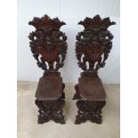 A RARE PAIR OF 19TH CENTURY HIGHLY CARVED OAK CASTLE HALL CHAIRS, 50.75” (h) x 17” (w) x 19.5” (d)