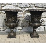 A PAIR OF BRONZED COLOURED CAST IRON GARDEN URNS, with floral motif and gadrooned rim