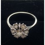 AN 18CT WHITE GOLD DAISY 7 STONE DIAMOND CLUSTER RING, large centre diamond surrounded by 6