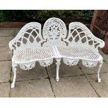 A CAST IRON THREE SEATER BENCH, with decoration on back, serpentine fronted, 4 foot 6in wide