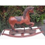 A WOODEN ROCKING HORSE with leather saddle, 4ft x 13in, head height 33in, saddle height 2ft.