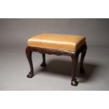 A MID 18TH CENTURY CARVED MAHOGANY IRISH STOOL, with stuffed over seat, a carved skirt showing a