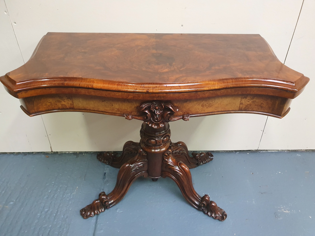 A VERY FINE BURR WALNUT 19TH CENTURY FOLD OVER CARD TABLE, with shaped top, raised on a carved