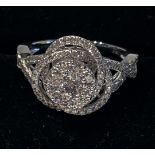 18CT WHITE GOLD DIAMOND CLUSTER RING in a swirling wave design the centre cluster represents the