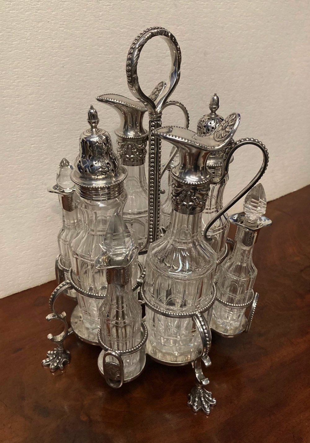 A 19TH CENTURY SILVER PLATED 8 BOTTLE CRUET SET, raised on four claw feet, c.1870, 10" high - Image 4 of 4