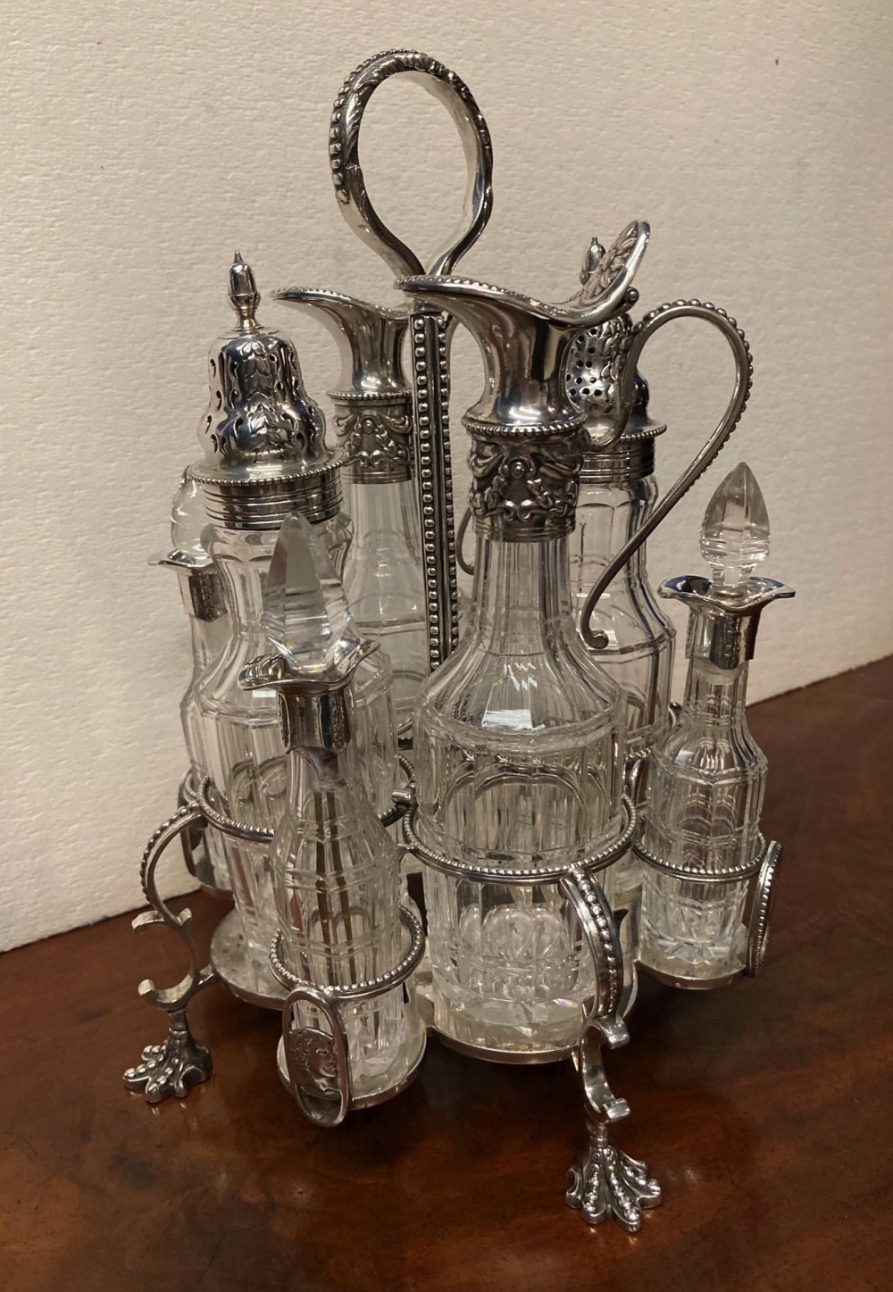 A 19TH CENTURY SILVER PLATED 8 BOTTLE CRUET SET, raised on four claw feet, c.1870, 10" high