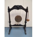 A 19TH CENTURY OAK FRAMED DINNER GONG - with carved mask head and brass gong, 48in x 32.25in x 21.