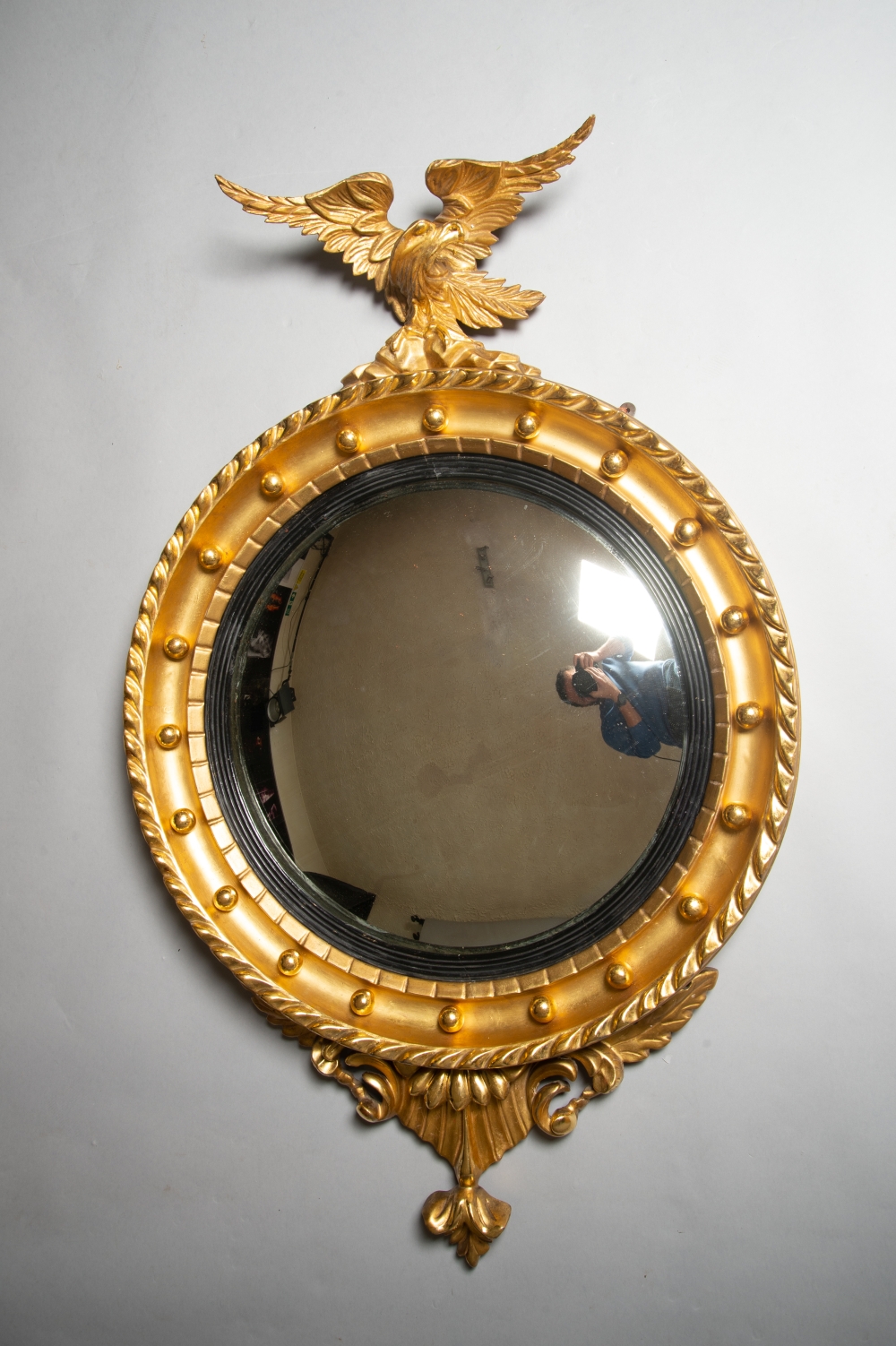 A VERY FINE WILLIAM IV CARVED GILTWOOD CONVEX MIRROR, with carved eagle perched on a cluster of