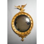 A VERY FINE WILLIAM IV CARVED GILTWOOD CONVEX MIRROR, with carved eagle perched on a cluster of
