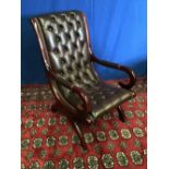 A LEATHER BUTTON BACKED ARMCHAIR, with mahogany frame, and curved arm rest, 57cm x 104cm approx