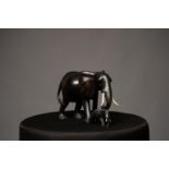 A 20TH CENTURY CARVED EBONY MOTHER ELEPHANT WITH BABY, with ivory tusks, c.1910, 10in x 7in