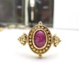 AN ANTIQUE 14CT YELLOW GOLD & CABOCHON SOLITAIRE RING, with grape vine detail to the shoulders,