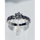 AN 18CT WHITE GOLD DIAMOND SOLITAIRE, with four diamonds to each shoulder all the diamonds are