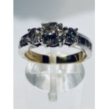 AN 18CT YELLOW & WHITE GOLD THREE STONE DIAMOND RING, with princess cut diamond shoulders, the