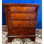 A MAHOGANY ‘BATCHELOR’ CHEST, with fold out top, over a short drawer, over 3 further drawers, raised