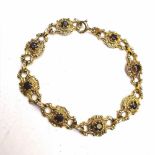 A 9CT SOLID GOLD FANCY LINK DECORATIVE GARNET BRACELET, with outstanding scroll link detail, 12.91