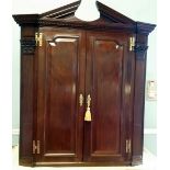 AN IRISH GEORGE III CARVED MAHOGANY HANGING CORNER CABINET, the architectural pediment is over a