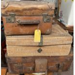 A MIXED LOT OF THREE EARLY 20TH CENTURY TRAVELLING SUITCASES, two leather and one wicker, largest