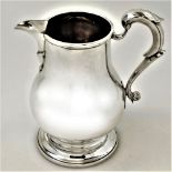 AN EARLY 20TH CENTURY SILVER JUG, London, 1927, by L A Crichton, of baluster shape with circular