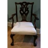 A MID 18TH CENTURY IRISH CARVED MAHOGANY ARMCHAIR, with scrolled and carved central splat back below