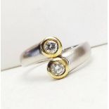 AN 18CT DIAMOND WHITE AND YELLOW GOLD TWO STONE TWIST RING, the white gold band at the front half of