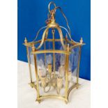 A BRASS & GLASS HANGING LANTER, with shaped sides having curved glass inserts, 52cm high approx.