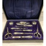 A SILVER VANITY SET TO INCLUDE, two powder bowls, a nail buffer, a nail file, a cuticle pusher,