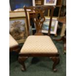 A PAIR OF GEORGE II CHAIRS, with carved back splats standing on carved cabriole legs and scroll