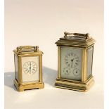 A PAIR OF FRENCH BRASS GOLD FINISH CARRIAGE CLOCKS, larger with enamel face and two subsidiary