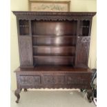 A LATE 19TH CENTURY JACOBEAN STYLE DRESSER WITH CARVED DOORS TO SIDE STANDING ON CABRIOLE LEG WITH