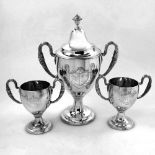 AN 18TH CENTURY IRISH SILVER SET OF TROPHY / CUPS, the larger with lid, Dublin, 1786, each with a