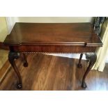 AN EARLY 19TH CENTURY IRISH MAHOGANY GAMES TABLE, the fold over top with shaped corners, has a baize