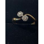 AN 18CT YELLOW GOLD TWO STONE TWIST RING, with two round brilliant cut diamond, .80cts, ring size M